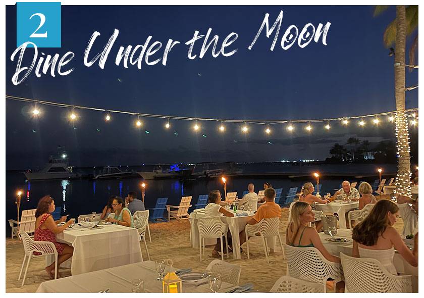 diners on beachfront under stringed lights